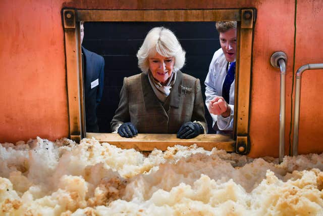 The Duchess of Cornwall looks at fermenting beer in a fermenting vessel (Ben Birchall/PA)
