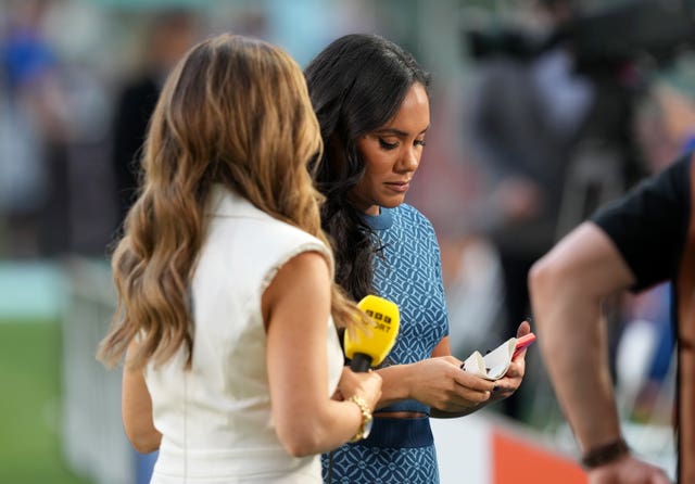 Alex Scott (right) holding the One Love armband