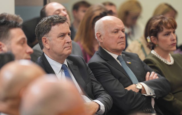 Work and Pensions Secretary Mel Stride (left) and Sir Iain Duncan Smith listening to Prime Minister Rishi Sunak giving his speech 