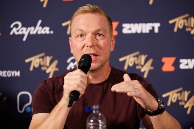 Sir Chris Hoy speaking into a microphone, in front of Tour de 4 signage