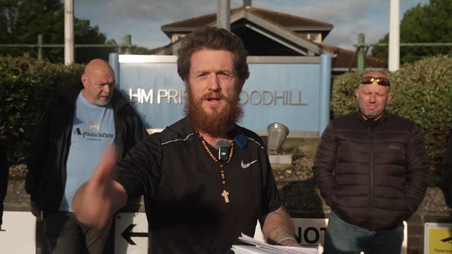 Tommy Robinson gesturing outside prison