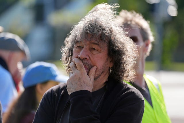 Actor Stephen Rea listens to a speaker at the protest