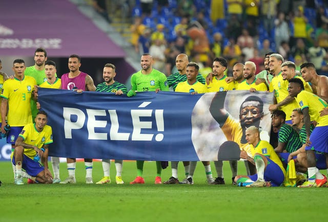 Brazil players bring a Pele banner on to the pitch at the World Cup