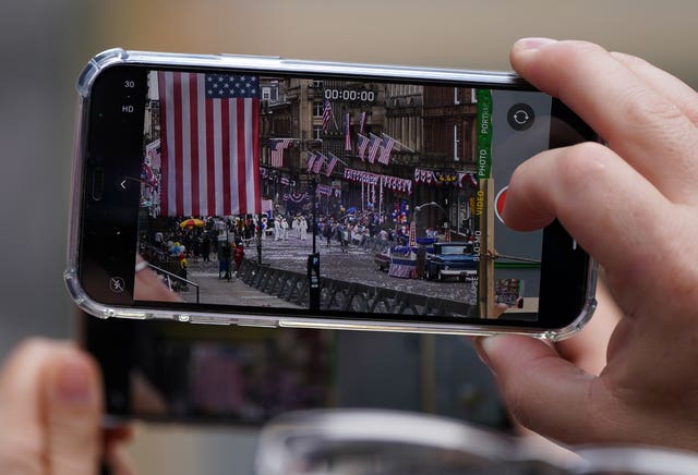 A member of the public takes a picture on their phone of a scene being filmed in Glasgow city centre during filming for what is thought to be the new Indiana Jones 5 movie (Andrew Milligan/PA)