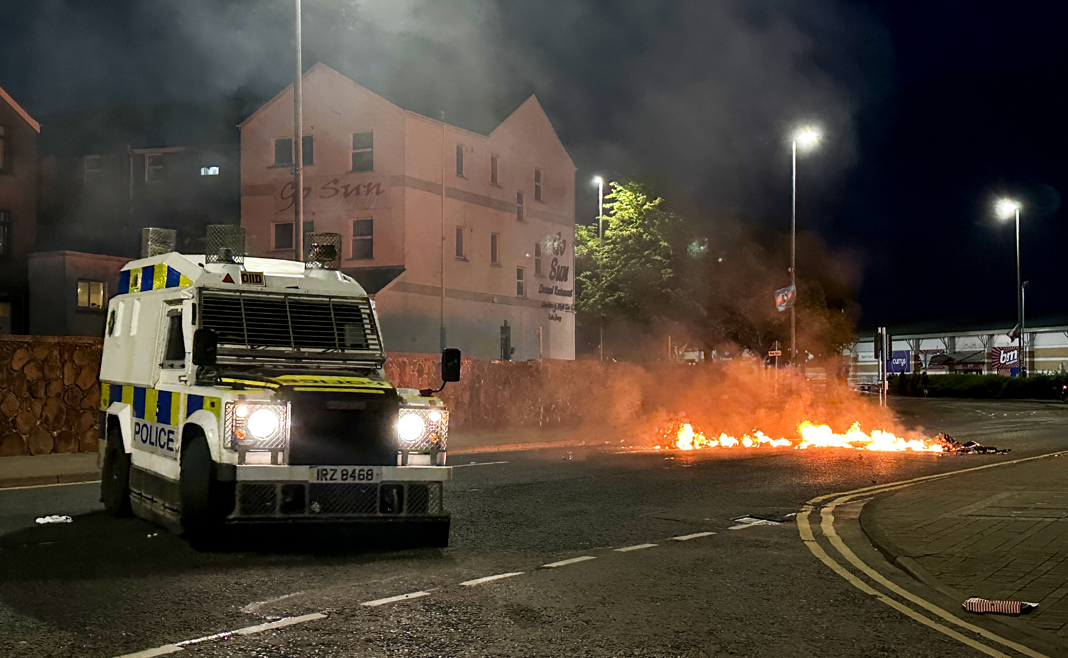 A PSNI vehicle near to debris on fire