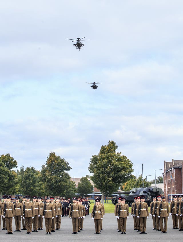 Two Apache helicopters perform a flypast during the parade
