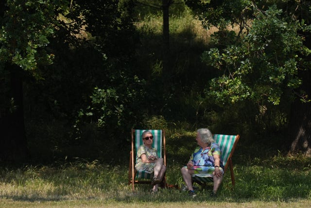 A man and a woman sitting on deck chairs in the shade