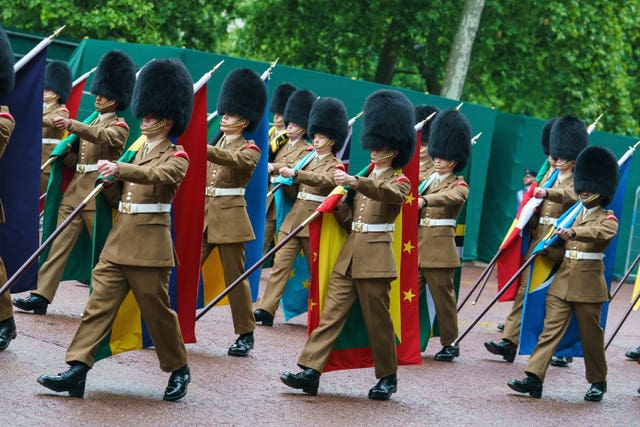 Troops carrying flags of Commonwealth nations march on The Mall, during an early morning rehearsal as service personnel from the Royal Navy, British Army, and Royal Air Force conduct a final early morning rehearsal through London ahead of Sunday’s Platinum Jubilee Pageant, which will mark the finale of the Platinum Jubilee Weekend