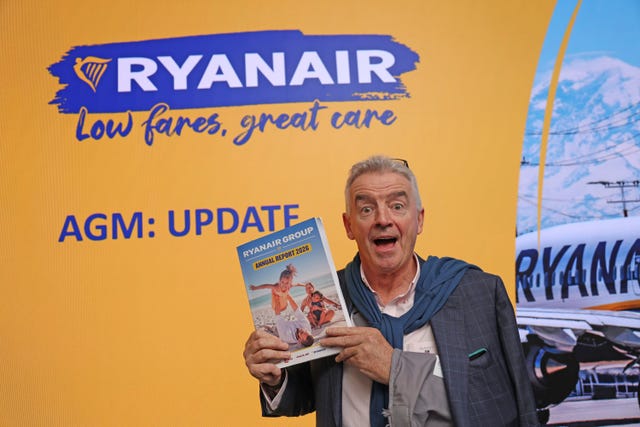 Michael O’Leary holding Ryanair's annual report, in front of Ryanair signage