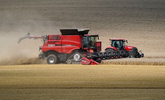 A tractor and a combine harvester in a field in Hampshire