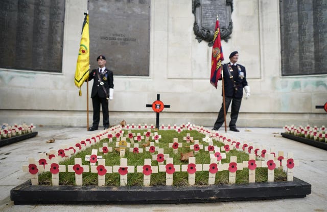 Standard bearers stand behind crosses planted in remembrance at the WWI memorial, Guildhall Square, in Portsmouth, as people gather to remember the war dead on Armistice Day