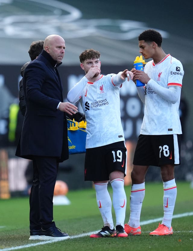 Liverpool manager Arne Slot, left, speaks with Harvey Elliott, centre, and Jarell Quansah on the touchline