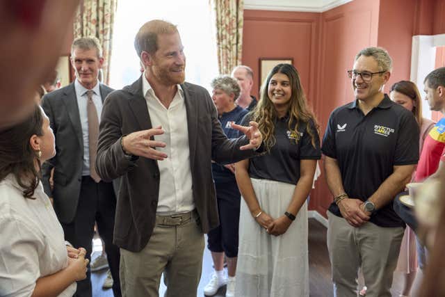 Harry smiles as he chats to people at the Royal Hospital Chelsea in London