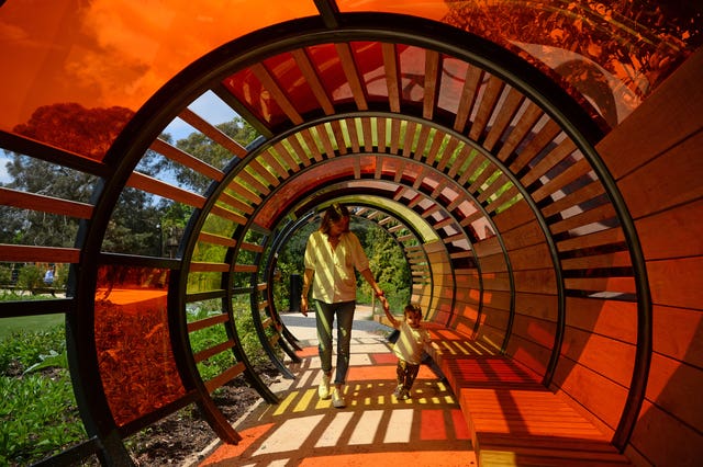 Louise Chitty and her daughter Luna walk through a light tunnel