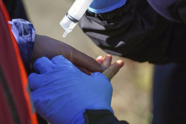 A police officer unglues a protester from Insulate Britain (Steve Parsons/PA)