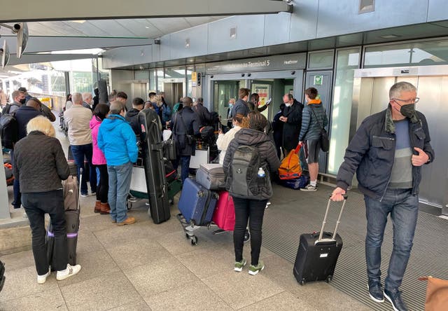 Passengers queue at the arrivals entrance of Heathrow Airport Terminal 5
