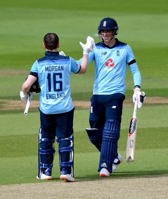 Eoin Morgan celebrates reaching his century with team-mate Tom Banton