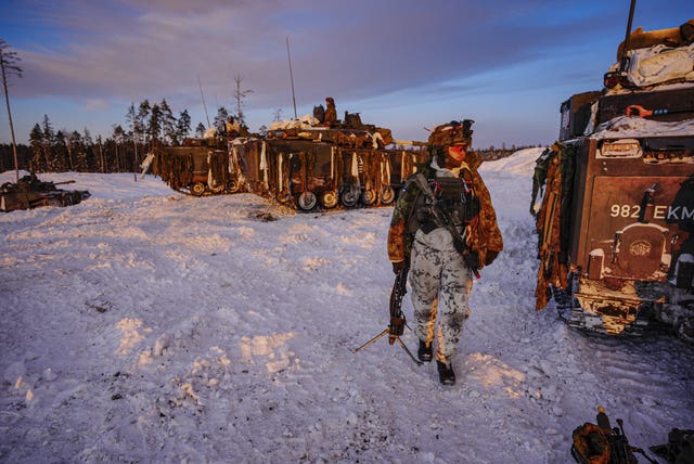 A soldier returns to his vehicle on snowy ground