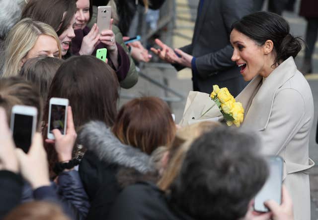 Meghan Markle being given yellow roses during a walkabout in Belfast (Brian Lawless/PA)