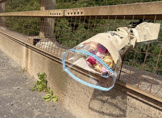Flowers had been left tucked into the roadside railings of Shank Bridge