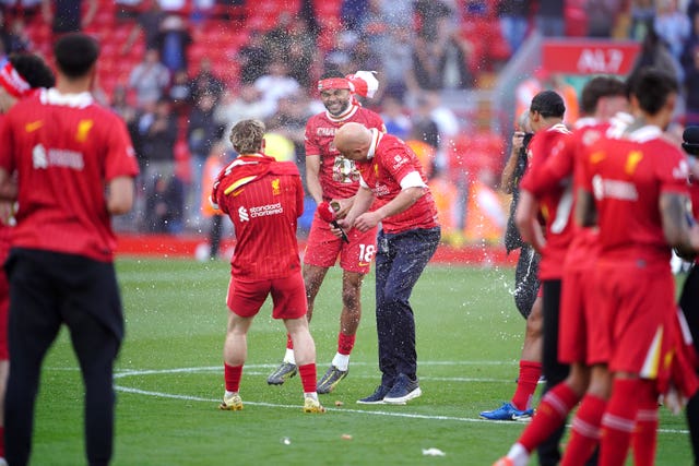 Liverpool manager Arne Slot (centre right) is sprayed with champagne by Harvey Elliott (centre left)