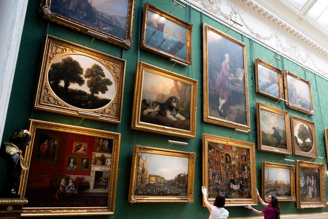 Royal Collection Trust staff adjust Johan Joseph Zoffany's The Tribuna of the Uffizi in the new display in the Picture Gallery at Buckingham Palace