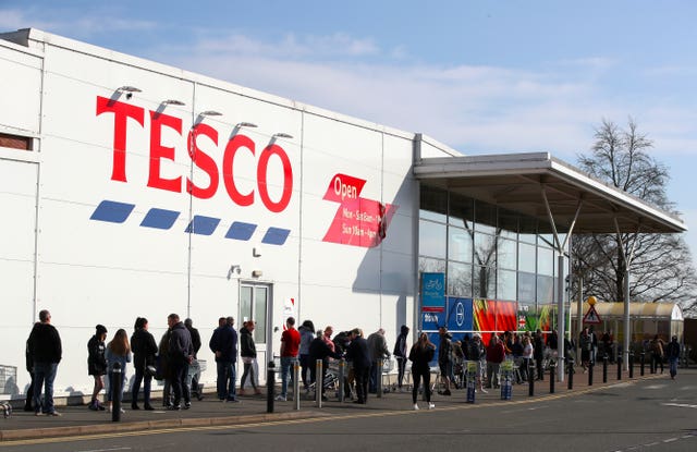 People queue outside a Tesco Extra store in Madeley, Shropshire