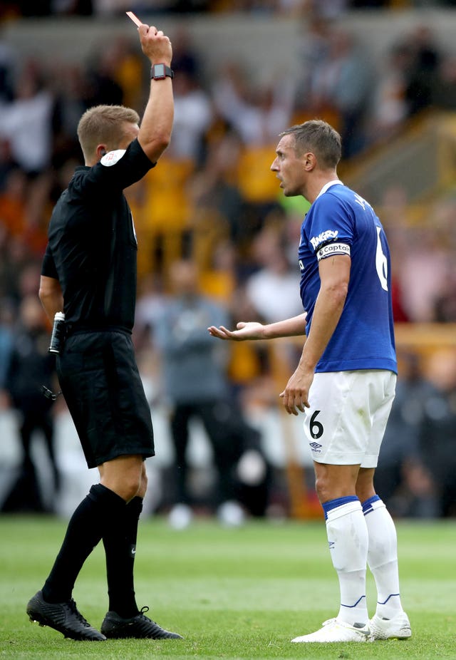 Referee Craig Pawson shows a red card to Everton’s Phil Jagielka