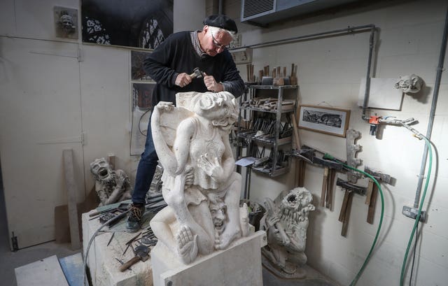 Master mason Pascal Mychalysin works on a gargoyle holding a cheese, to represent the Cheese Rollers of Gloucestershire, as part of a project for Gloucester Cathedral to depict local areas in a more modern way