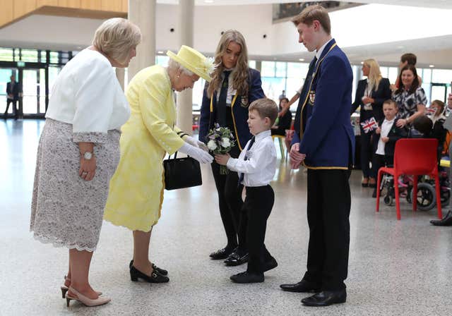 The Queen receives a posy of flowers from Archie Wilson