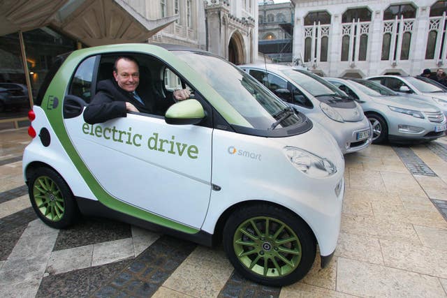 Quentin Willson sits in an electric car