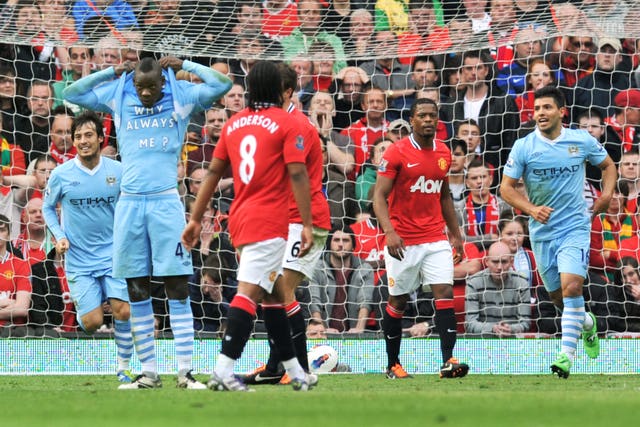 Mario Balotelli, second left, celebrates by revealing his 'Why Always Me?' T-shirt after scoring in Manchester City's 6-1 win over Manchester United