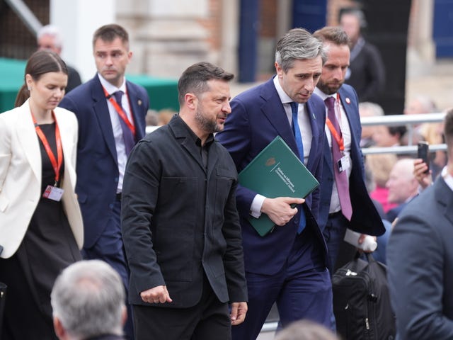 Volodymyr Zelensky walking alongside Simon Harris