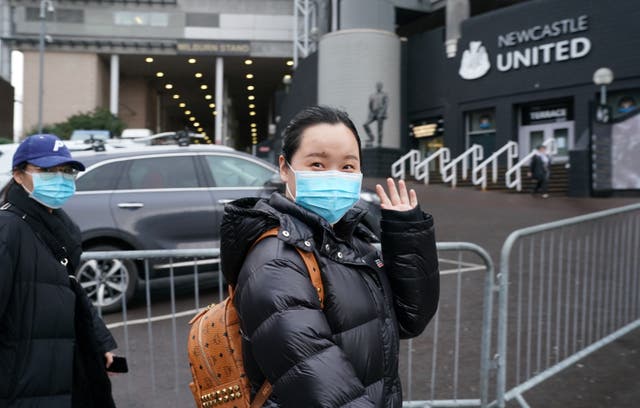 A person wearing a face mask outside at St James' Park