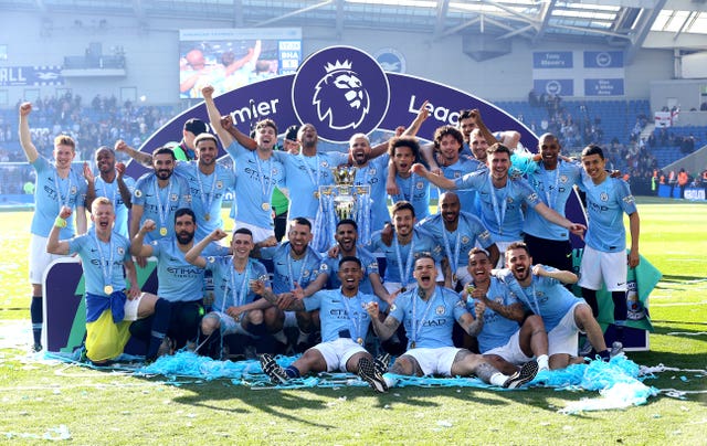 Manchester City players celebrate with the Premier League trophy after their 4-1 win at Brighton