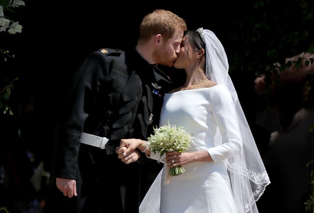 Prince Harry and Meghan Markle kiss outside St George’s Chapel in Windsor Castle after their wedding (Jane Barlow/PA)