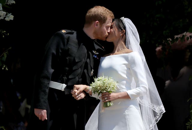 Prince Harry and Meghan Markle kiss outside St George's Chapel in Windsor Castle after their wedding (Jane Barlow/PA)