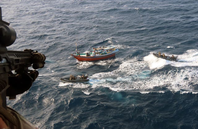 The dhow crew holding their hands up in surrender as the Royal Marines close in