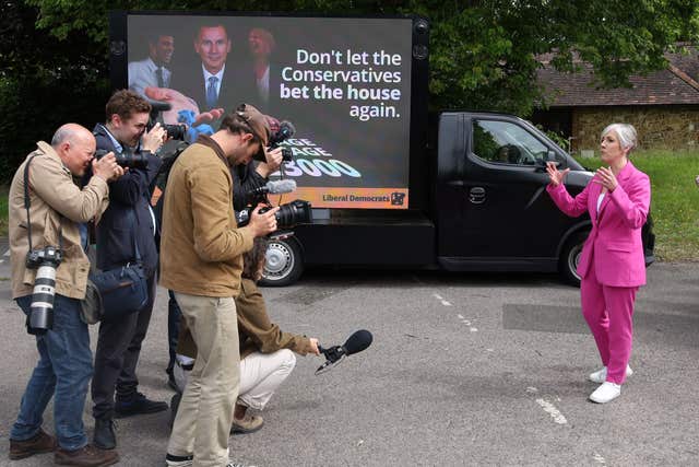 Liberal Democrat deputy leader Daisy Cooper speaks to the media in Farncombe, in the Godalming and Ash constituency which Chancellor Jeremy Hunt is contesting in the General Election, in front of a billboard with pictures of Rishi Sunak, Mr Hunt and Liz Truss, and with the messages 'Don't let the Conservatives bet the house again' and 'Average mortgage up £3,000'