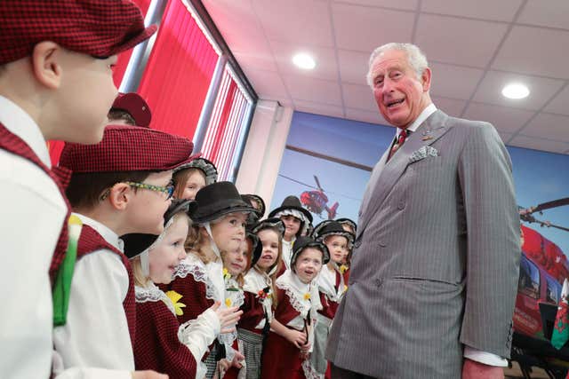 The Prince of Wales meets choir children from the Encore Stage School at the south Wales airbase of Wales Air Ambulance (Aaron Chown/PA)