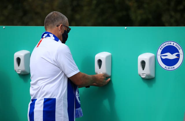 A fan attending a Brighton v Chelsea pre-season friendly using a hand sanitising station at the Amex Stadium 