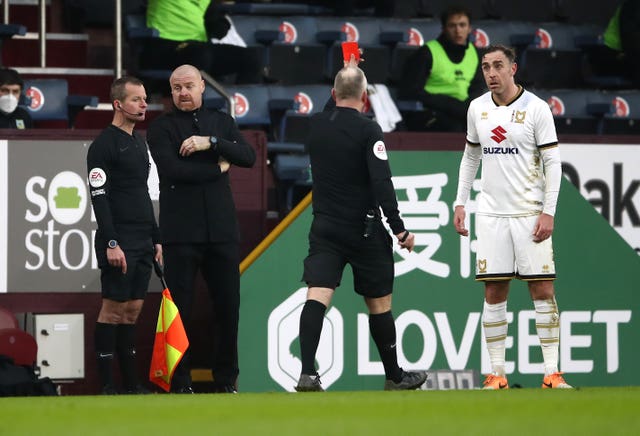Referee Jon Moss, centre, shows a red card to Richard Keogh, right, before overturning the decision on review