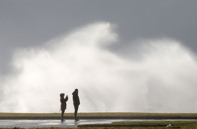 Onlookers gaze at waves during the windy weather in Ardrossan, North Ayrshire