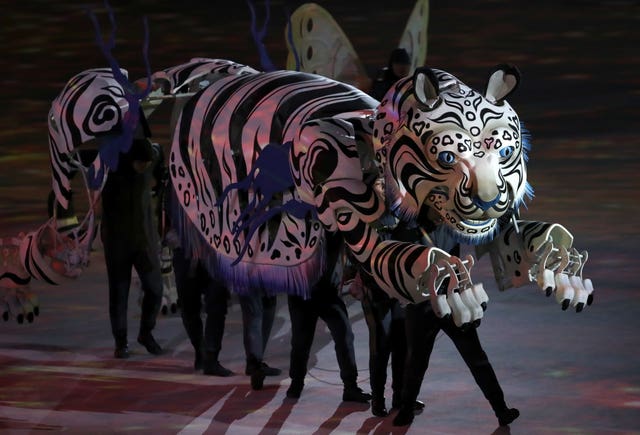 Performers take a tiger by the tail during the colourful opening ceremony (AP) 