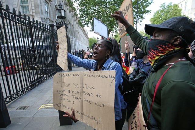 People gather during a rally at the gates of Downing Street
