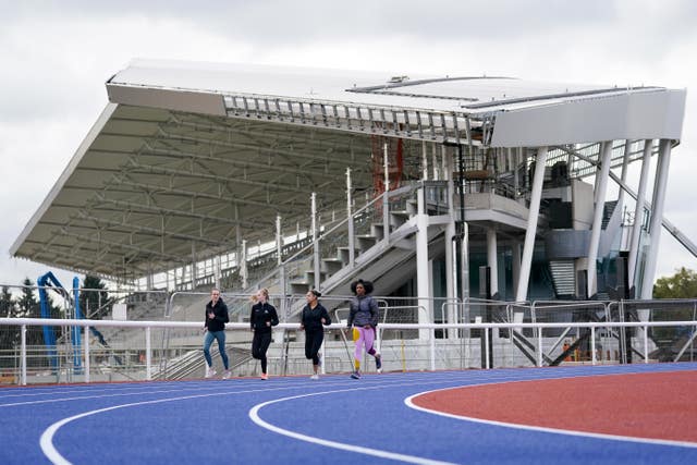 Laura Muir (L) and Kadeena Cox (R), run alongside Birhcfield Harriers sports club members Amy Harland and Sophia Deans