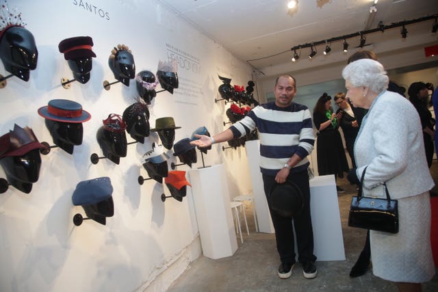 The Queen talks to milliner Harvy Santos (Yui Mok/PA)