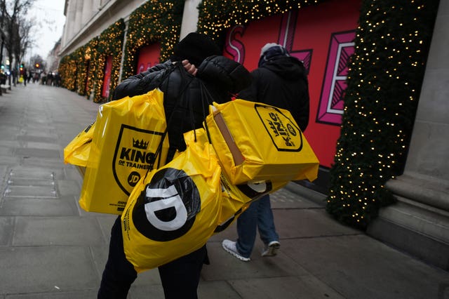 A man carries bags from JD Sports
