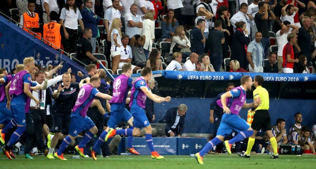 Roy Hodgson watches on as Iceland players and staff celebrate a 2-1 win over England at Euro 2016