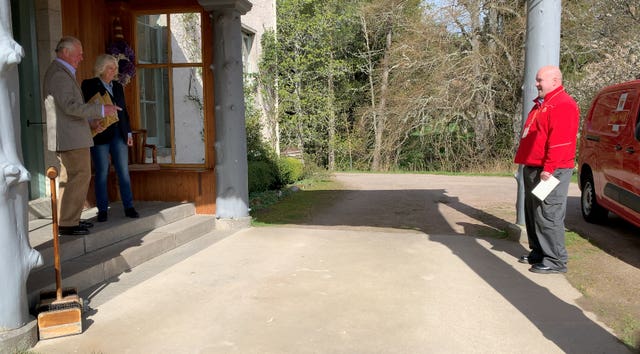 Postman Neil Martin talks at a safe distance to Charles and Camilla
